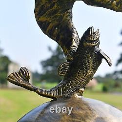 Grand aigle doré sur sculpture de jardin en forme de boule en aluminium ornant l'extérieur